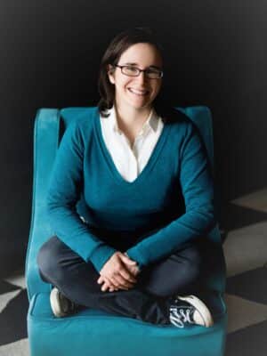 STACKED book author Emily Guy Birken sitting cross legged in a chair