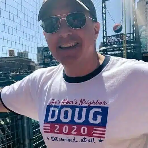 smiling man wearing sunglasses and a baseball hat