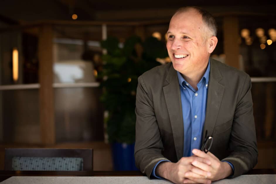 man seated at desk looking happily off in the distance