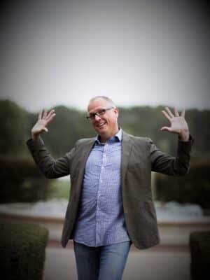 STACKED book author Joe Saul-Sehy standing with hands in air