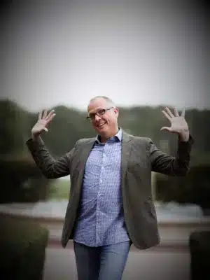 STACKED book author Joe Saul-Sehy standing with hands in air